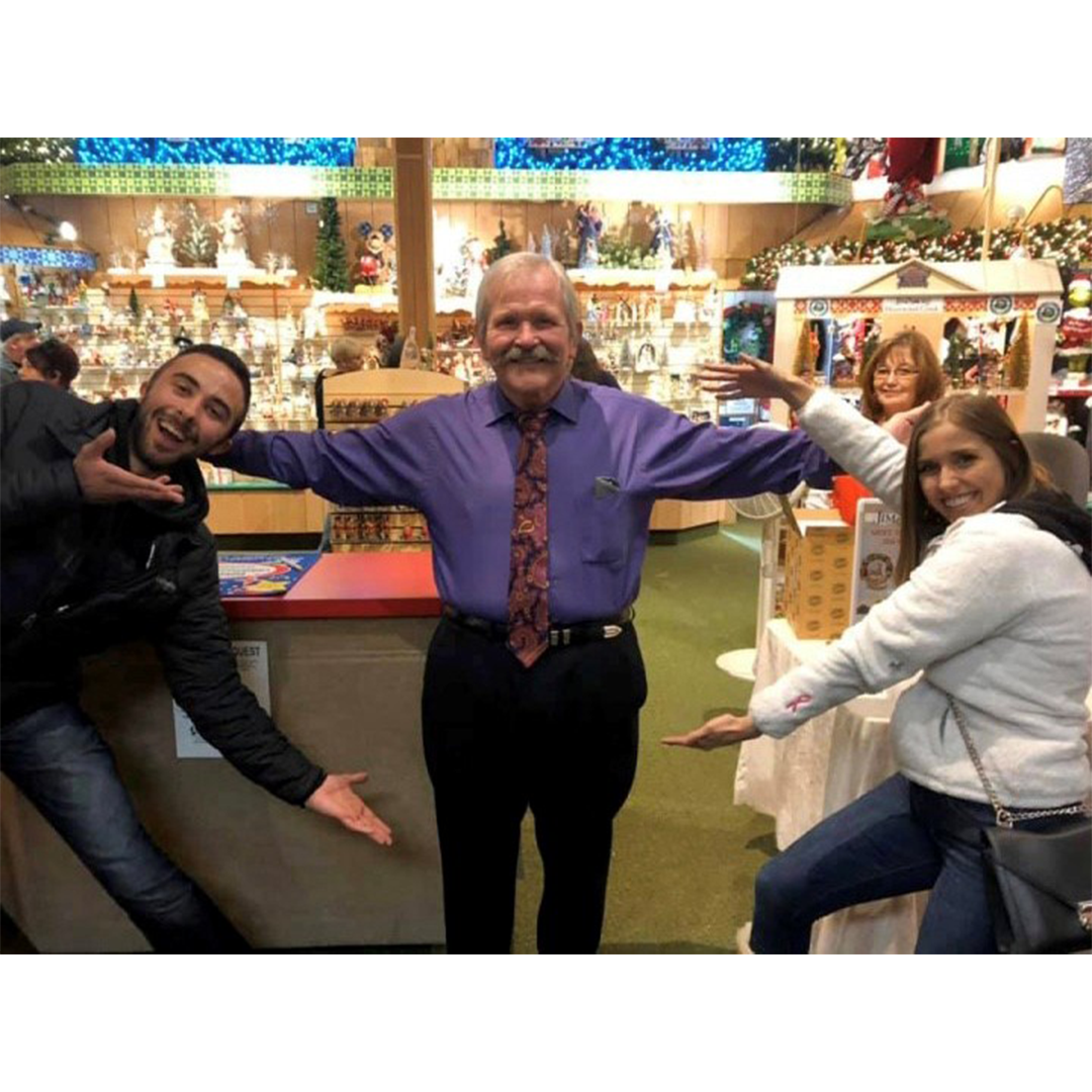 Jim in a store with two fans embracing him