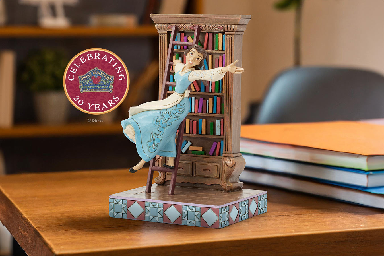 Statue of a woman in a blue dress with a bookshelf, on a wooden surface with books and a decorative emblem.