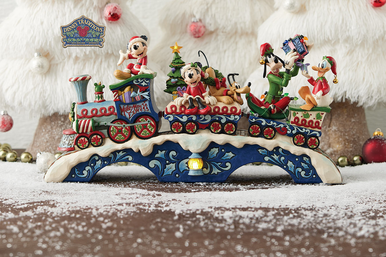 Decorative Christmas train set with animated characters on a snowy platform.