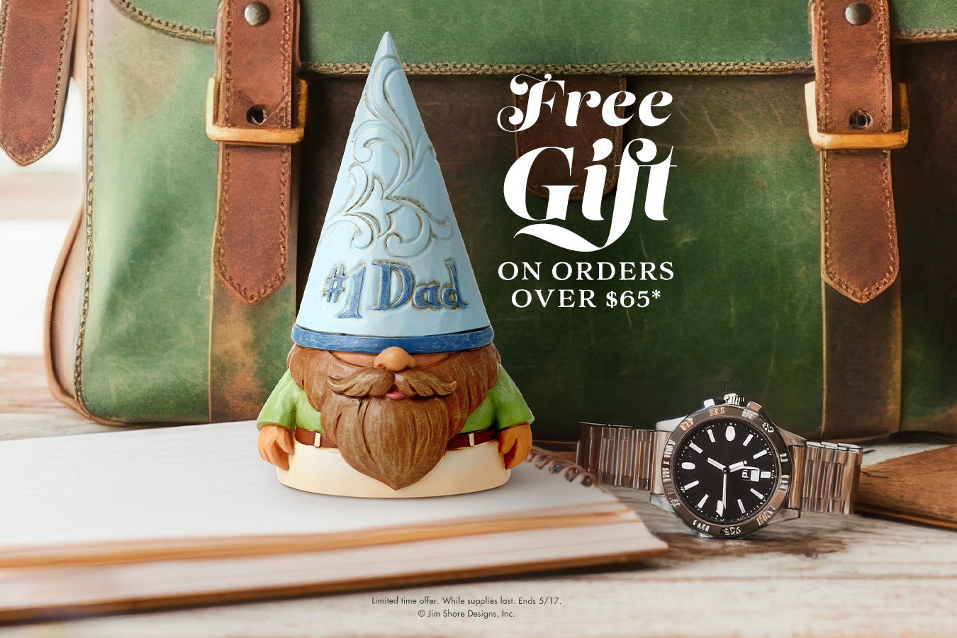 Wooden gnome figurine with a blue hat labeled '#1 Dad' next to a watch and green leather suitcase.
