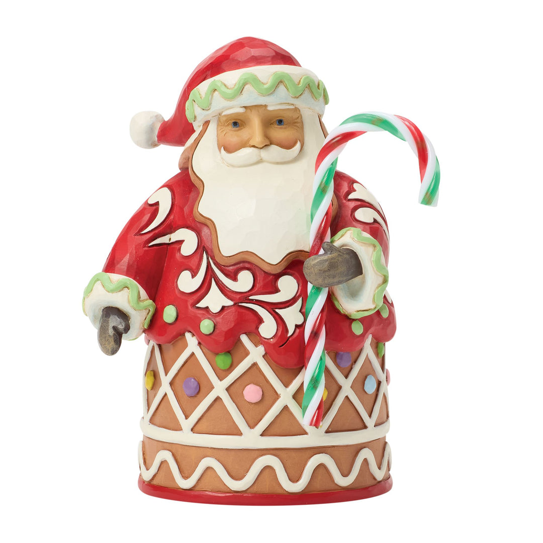 Decorative gingerbread man Santa Claus figurine holding a candy cane on a white background