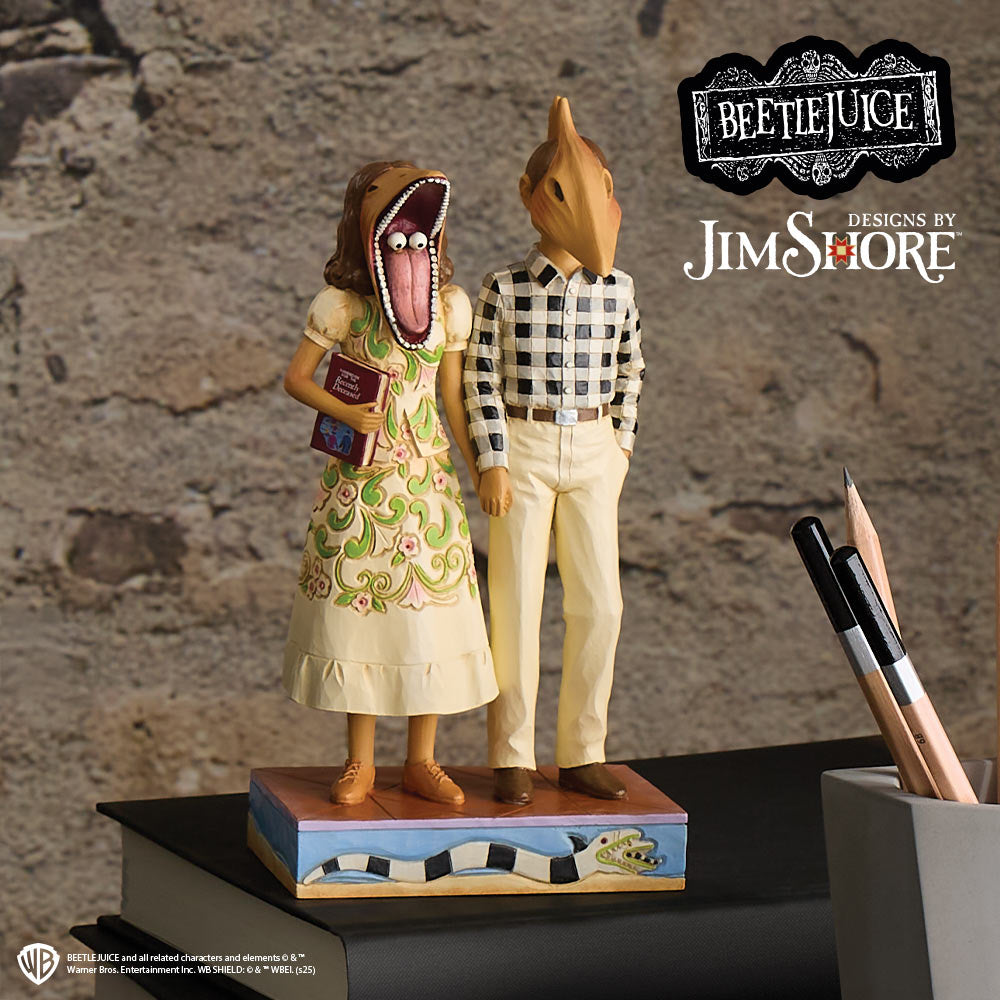 Statue of a man and woman with animal heads from 'Beetlejuice' by Jim Shore on a stone surface.