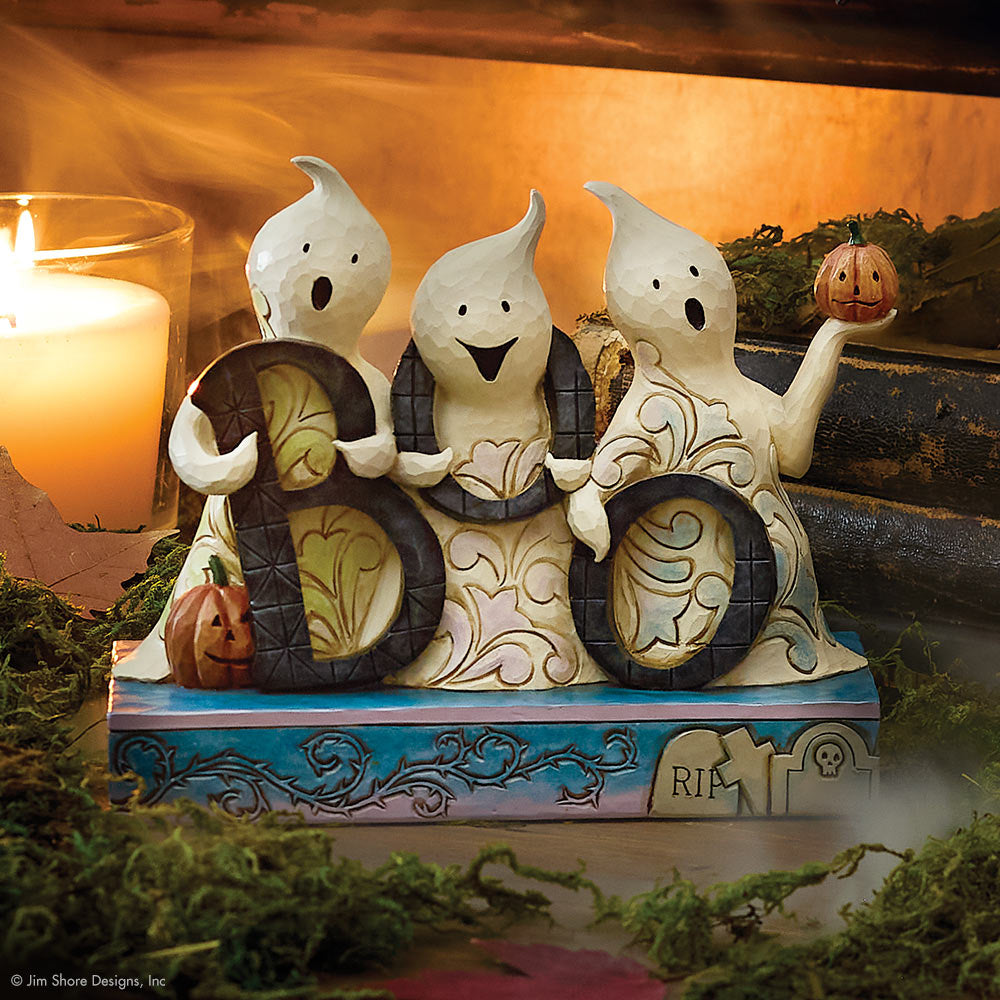 Decorative Halloween figurine with ghosts holding 'BOO' letters, surrounded by pumpkins and candles.