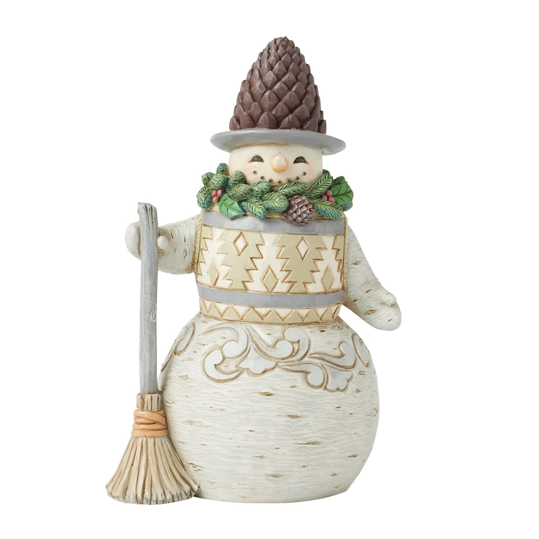 Decorative snowman figurine with a broom, pine cone hat, and wreath on a white background